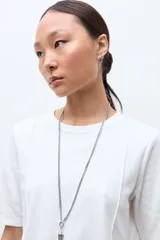 Remera de algodón color blanco, con cuello redondo, mangas cortas y diseño con costuras verticales decorativas en el frente.