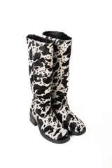 Botas de cuero con estampado animal print de vaca en blanco y negro, con taco de 4cm y caña alta de 37cm.