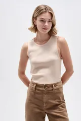 Musculosa de algodón negra con cuello redondo y breteles anchos, diseño ajustado al cuerpo y detalle de botones en el lateral con dobladillo asimétrico.