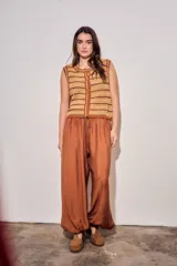 Babucha de viscosa color ladrillo, de tiro alto con cintura elástica fruncida y cordón ajustable del mismo tejido, con diseño fluido y puños ajustados en los tobillos.