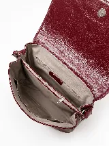 Cartera bandolera de cuero vacuno color bordó, con solapa frontal de textura símil cocodrilo y detalles de costuras pespunteadas en blanco. Cuenta con correa ajustable y cierre superior.