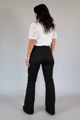 Pantalón de jean negro de tiro alto, corte ajustado en la parte superior y botamanga levemente acampanada. Cuenta con bolsillos traseros clásicos y trabillas para cinturón.