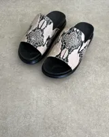 Sandalias chatas de cuero vacuno color beige con estampado de piel de serpiente.