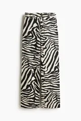 Pantalón de tiro alto confeccionado en lona de algodón con estampado de cebra, corte de perneras rectas y cierre de botones metálicos en la cintura.
