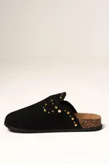 Zueco de gamuza color negro con detalle de tachas metálicas doradas en la parte superior y lateral. Cuenta con una plantilla de corcho y suela de goma antideslizante.