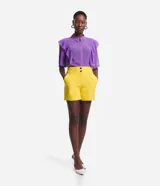 Bermuda roja de poliéster con cintura elástica, bolsillos laterales y cierre con cremallera y botones.