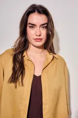 Camisa de lyocell color mostaza, de corte holgado, mangas cortas y cierre frontal con botones.