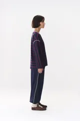 Remera de manga larga con corte oversized, color azul marino con cuello redondo en contraste color marrón. Presenta costuras decorativas a contratono hechas a mano en la zona de los hombros y logo bordado en el centro del pecho.