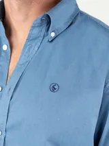 Camisa celeste de algodón con cuello abotonado, corte regular fit, manga larga con puños simples y logo bordado en el pecho.
