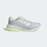 Championes de running Adidas Supernova Comfortglide para mujer, diseñados con un exterior de malla textil y sintética en color gris claro. Incorporan la tecnología Dreamstrike en la mediasuela para una amortiguación superior, detalles reflectantes para mayor visibilidad y una suela en contraste de color verde lima con acentos violetas.