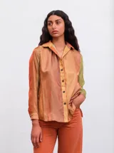 Camisa de manga larga con cuello clásico y cierre frontal con botones. Diseño con degradado de colores en tonos naranja, amarillo y verde.