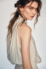 Top de cuello halter con diseño holgado y fruncido. Presenta detalle de abalorios decorativos en el escote y bajo con acabado elástico.