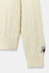 Jersey de punto trenzado confeccionado en algodón, color blanco, con cuello redondo, manga larga y detalles de textura en relieve en el pecho. Cuenta con la colaboración especial de Fruit of the Loom y Zara.