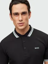 Remera polo de algodón color gris oscuro, marca Boss, modelo Paddy. Corte regular fit, cuello y puños con ribete doble en blanco y gris. Logo bordado en el pecho.