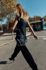 Vestido corto de cuello subido y sin mangas, confeccionado en tejido satinado. Presenta un detalle de fruncido lateral con abertura frontal y aplicación de encaje en el bajo.