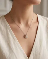 Collar de acero con dije colgante en forma de media luna que contiene una circonia brillante en su interior.