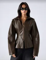 Chaqueta de efecto cuero en color marrón chocolate, con silueta entallada, cierre frontal con cremallera, cuello amplio y mangas con volumen.