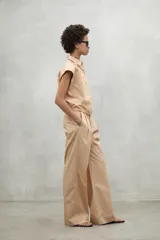 Camisa azul marino con cierre frontal de botones y dobladillo ajustable con cordones de tela.