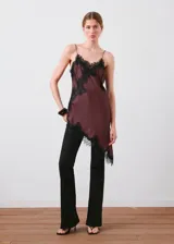 Jeans negros de tiro alto y estilo flare, con diseño largo, cinco bolsillos y cierre frontal de cremallera y botón.