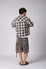 Camisa de manga corta de popelina cuadrillé en tonos marrón, blanco y gris, con diseño boxy fit, cuello camisero, cierre frontal de botones, bolsillo en el pecho con detalle bordado y dobladillo recto.
