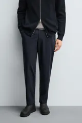 Pantalón regular fit color azul marino, confeccionado en tejido elástico. Cuenta con bolsillos frontales, bolsillos traseros de vivo con botón y cierre frontal con cremallera y botón.