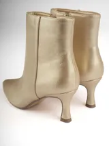 Botín dorado de cuero sintético con punta fina y taco kitten heel.