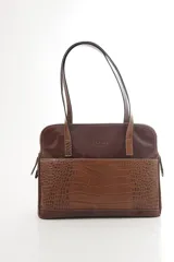Cartera de hombro tipo portafolio confeccionada en cuero vacuno, con diseño estructurado que combina marrón liso y un panel frontal en cuero texturizado color mostaza. Posee doble asa larga y cierre superior.
