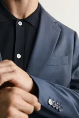 Blazer regular fit azul marino confeccionada en tejido con 20% de lana. Cuenta con cuello con solapas de muesca, manga larga con botones en los puños, bolsillos de vivo en el pecho y de solapa en la cadera, y cierre frontal con botones.