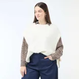 Sweater sin mangas de tejido de punto en color beige, con cuello redondo y diseño holgado con aberturas laterales ajustables mediante lazos.
