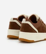 Championes marrones de caña baja, con lengüeta de sherpa color crema y cordones gruesos tricolor.