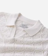Camisa polo blanca de manga corta con cuello y tejido de punto con textura calada en forma de rombos.