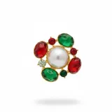 Broche de base metálica dorada con una perla central grande, rodeada por cristales facetados en tonos rojo y verde.