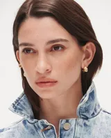 Aros pequeños de bronce con forma irregular y acabado liso, estilo huggie o argolla gruesa.