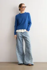 Sweater clásico de punto color azul, con escote redondo, mangas largas y puños anchos.