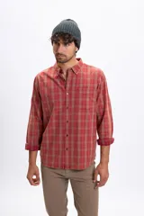Camisa de manga larga con estampado de cuadros, confeccionada en tela de franela con efecto lavado. Presenta cuello clásico con botones, cierre frontal abotonado y un bolsillo en el pecho.