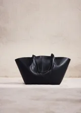 Bolso tipo shopper de efecto piel, con doble asa de hombro, cierre de botón magnético y bolsillo interior con cremallera.