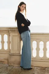 Jean de cinco bolsillos en denim de algodón rígido, de diseño curvo con volumen y corte holgado de cadera a muslo, algo más ceñidas en el bajo. Cintura clásica con cierre y botón.