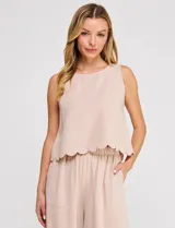 Pantalón palazzo de tiro alto color beige, confeccionado en mezcla de lino y viscosa, con silueta suelta y fluida, cintura elastizada, bolsillos delanteros aplicados y ruedo festoneado de corte tobillero.