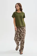 Remera de algodón verde militar, de manga corta y corte holgado, con cuello redondo a la base y detalle de cinta perforada en los hombros.