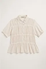 Camisa beige de manga corta con cuello camisero, detalles de encaje y cierre frontal con botones.