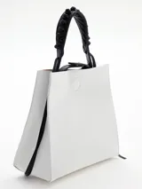 Cartera celeste de cuero con asa corta trenzada color negro y tiras colgantes decorativas.