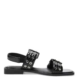Sandalias planas Miss Carol modelo Kelmo, color negro, con tiras anchas ajustables mediante hebillas metálicas y detalle de ojales. Presentan una suela baja y punta cuadrada.