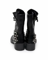 Bota corta color chocolate, con taco cuadrado y diseño de caña media. Presenta múltiples correas con hebillas metálicas y tachas decorativas alrededor del tobillo y en la parte superior de la caña.