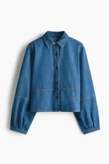 Camisa de denim de mezcla de algodón y lyocell, de corte corto, con cuello clásico, mangas largas abullonadas y cierre frontal con botones oscuros.
