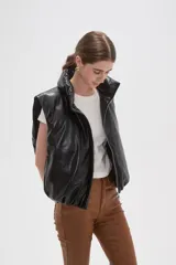 Chaleco puffer sin mangas confeccionado en cuero sintético negro, con cuello alto y cierre frontal.