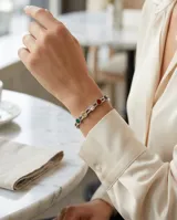 Esclava rígida de acero con diseño de eslabones circulares engastados con circonias de colores.