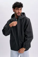 Campera gris oscuro con textura, capucha con cordón ajustable, cierre frontal y bolsillos frontales con solapa.