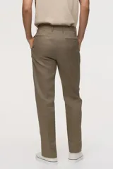 Pantalón de traje de lino color tostado, corte slim fit con piernas de corte recto, pinzas marcadas y trabillas para cinturón.