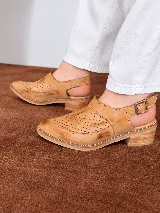 Zapatos de cuero color tostado con diseño calado en el empeine, talón abierto, pulsera regulable con hebilla lateral y taco bajo efecto madera.