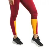Calza deportiva de tiro medio con diseño de paneles en contraste, combinando color bordó y amarillo en la parte inferior de las piernas.